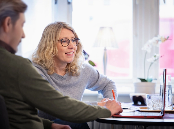 Bild på psykolog Lena Norell som handleder en person framför en laptop