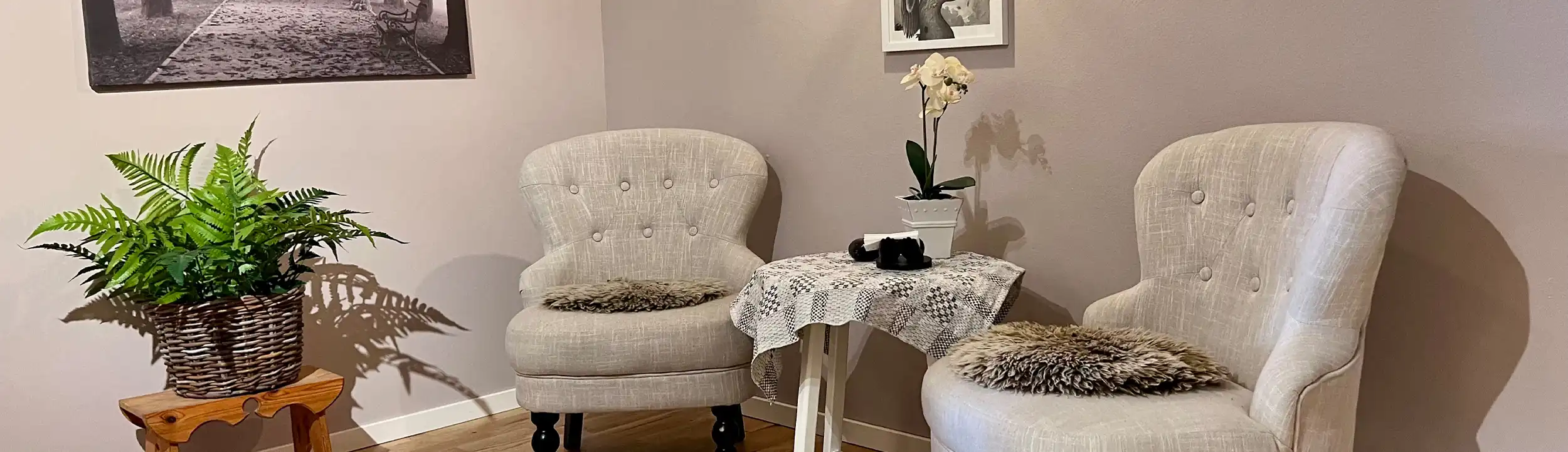Bild på två fåtöljer och en piedestal med en ormbunke