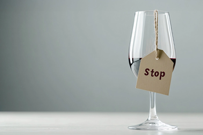 Bild på ett glas rödvin med en stoppskylt